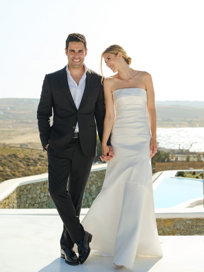 blonde bride wearing minimal classy strapless wedding dress and classy undo chignon and groom portrait shooting sea view seafront summer wedding in mykonos Greece at Alemagou ftelia classy classic designed by Only for you events